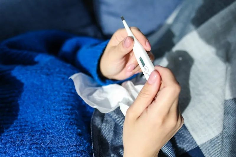 Person holding thermometer — fever management