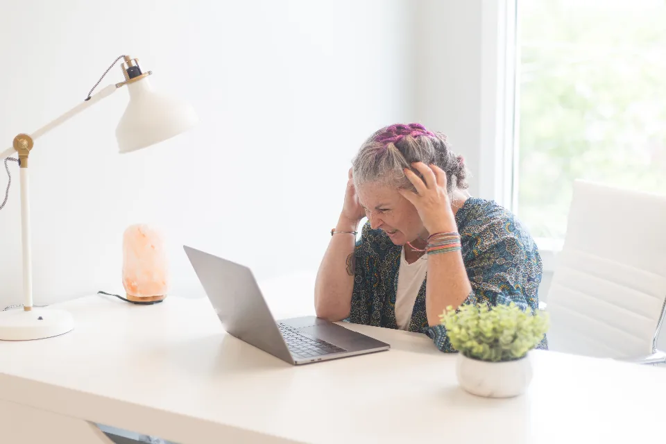 Stressed woman holding her head at a desk