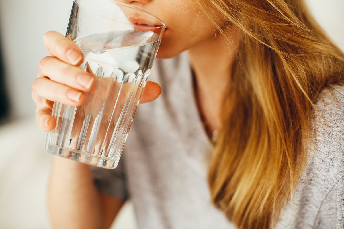 Woman drinking water — hydration for health and recovery