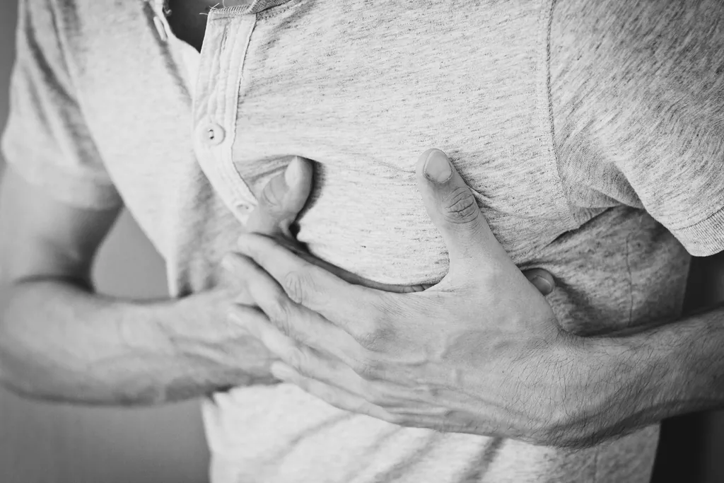 Person holding a hand to their chest in discomfort