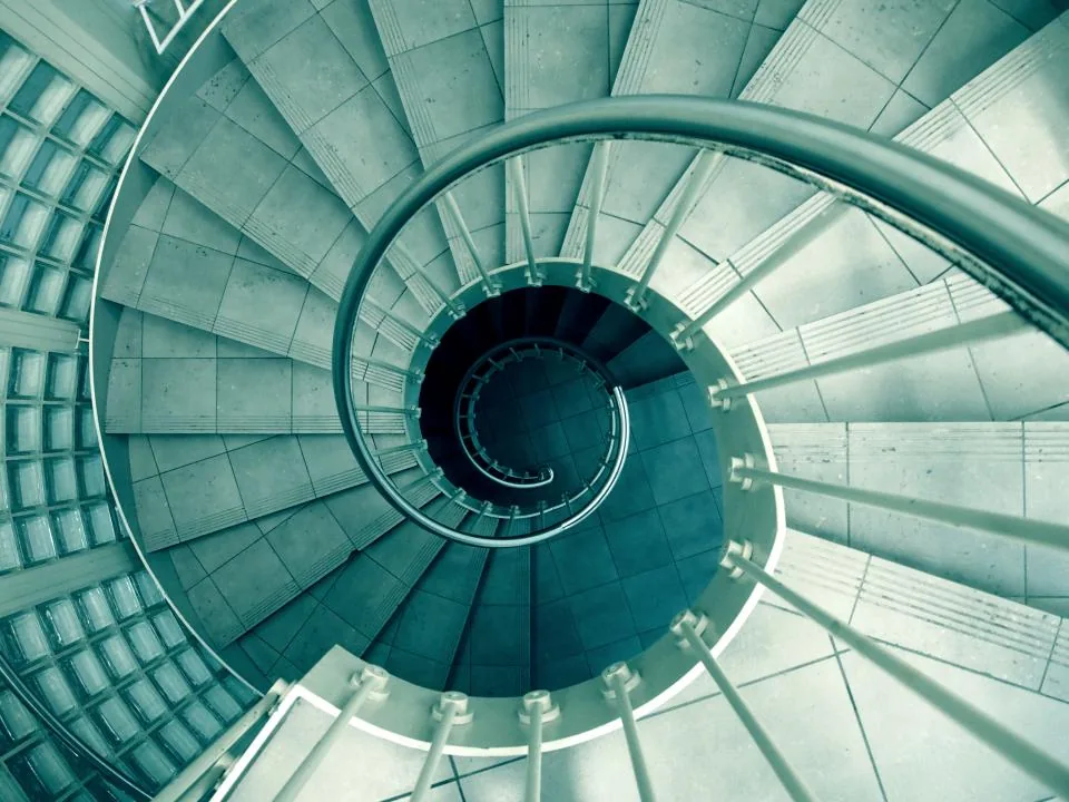 Looking down a spiral staircase, evoking the dizziness felt when standing up