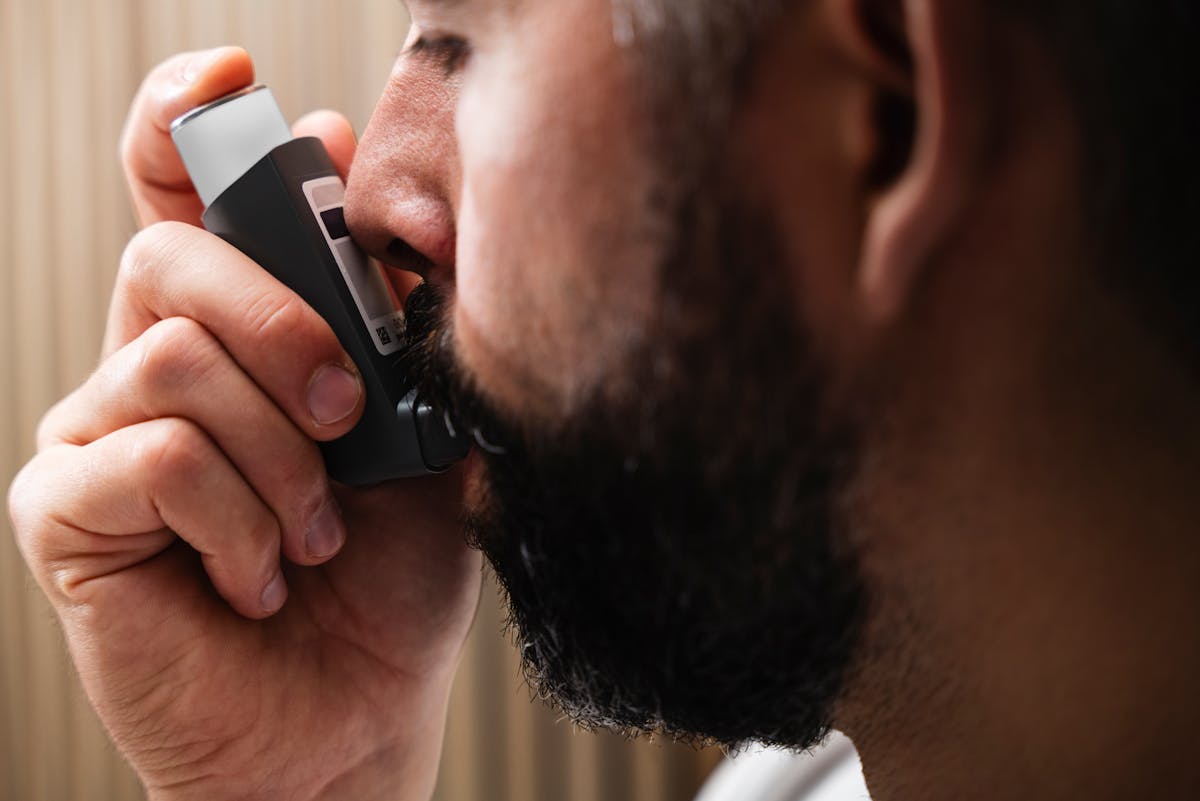 Person using inhaler for asthma relief