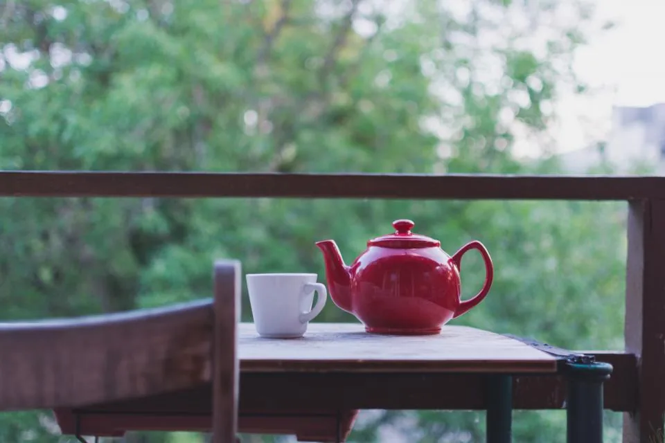 Teapot and cup of hot tea for soothing a sore throat during recovery