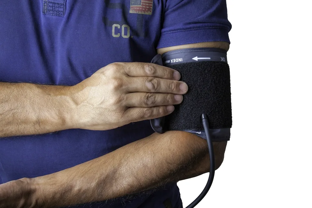 A person fastening a blood pressure cuff to measure their blood pressure at home