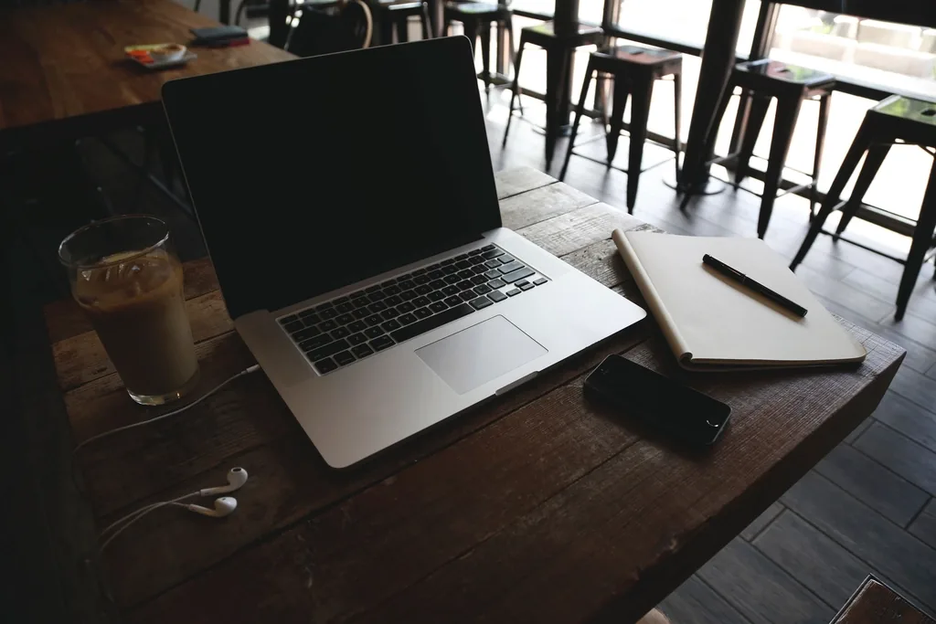 A laptop and smartphone on a desk, representing an online telehealth visit