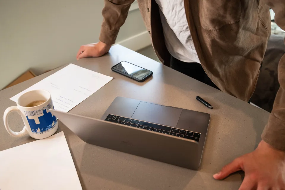 A person working at a laptop, comparing online telehealth platforms