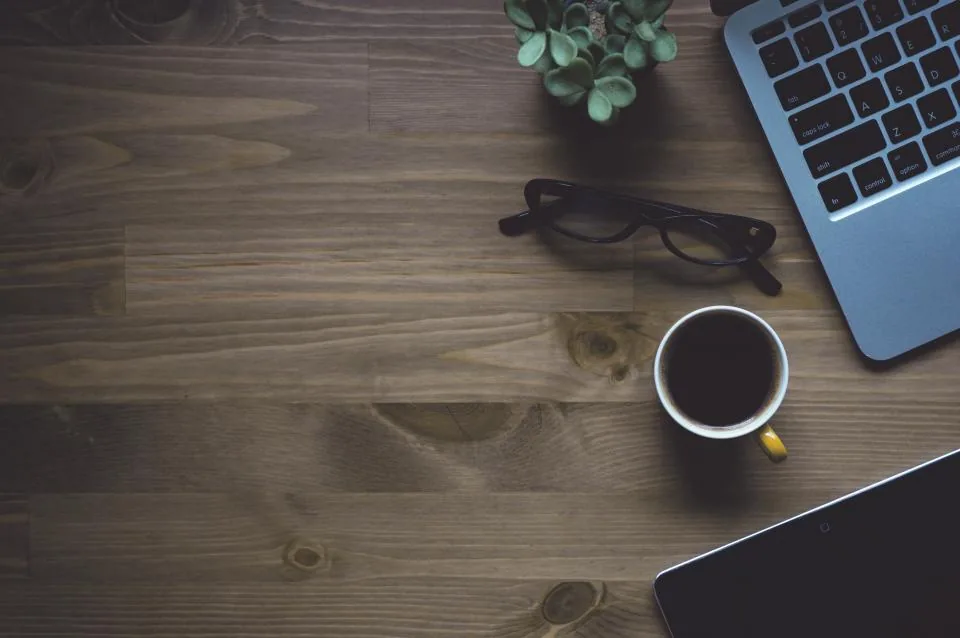 A laptop and coffee on a desk for an online telehealth visit