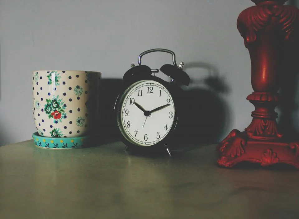 A bedside alarm clock in dim evening light, evoking sleepless nights and insomnia