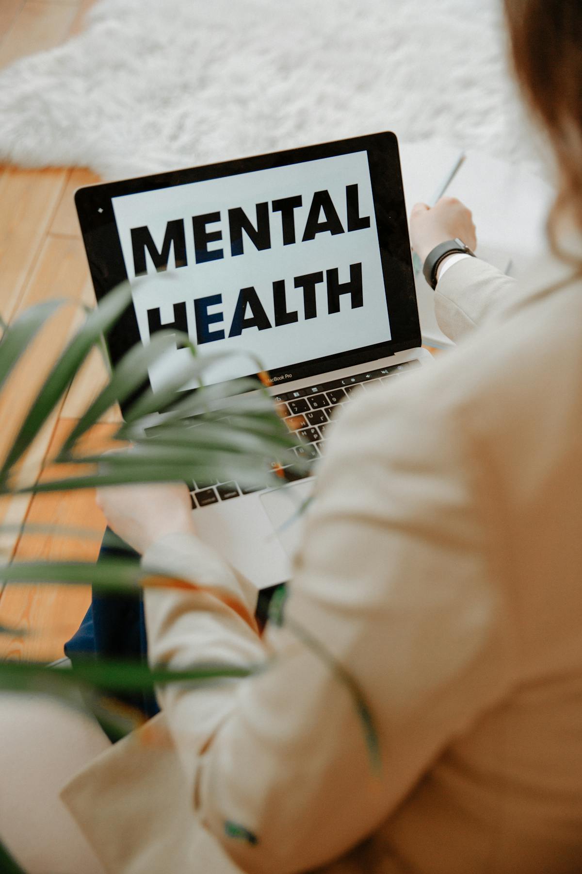 Person working from home at a laptop &mdash; telehealth visit for a mental health day doctor's note