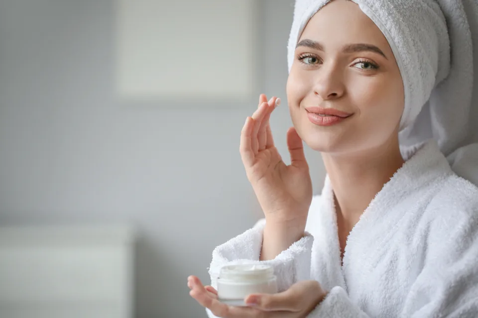 A person applying skincare cream as part of a clear-skin routine