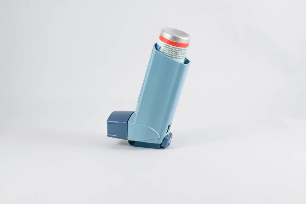Blue asthma rescue inhaler on a plain background