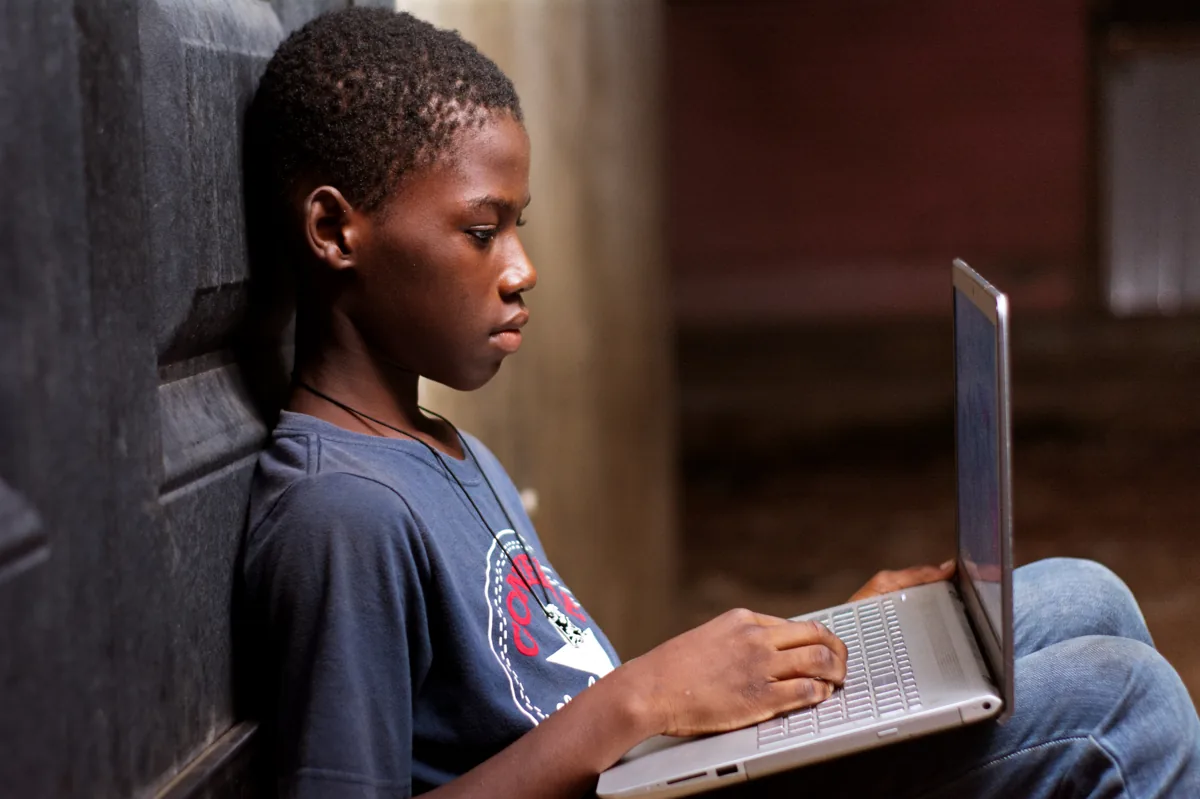 A child using a laptop, representing a telehealth visit for kids