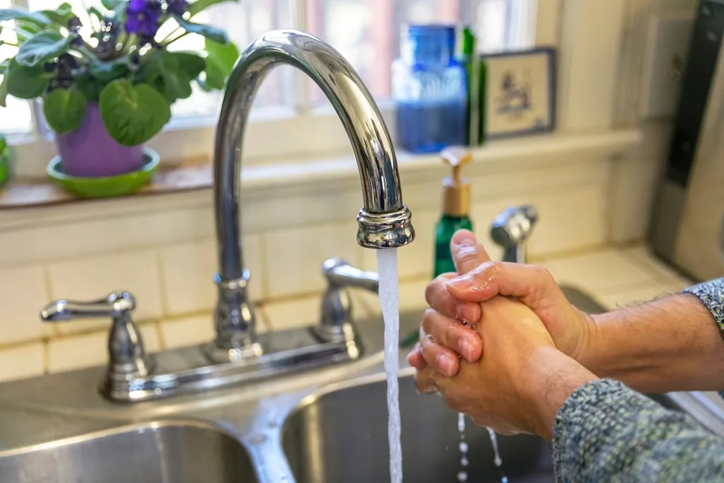 Person washing hands at a sink, the key step in preventing pinworm reinfection
