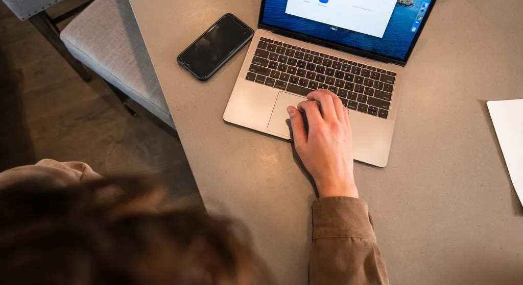 Person using a laptop at home to start an online telehealth visit