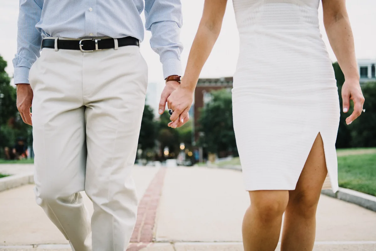 A couple holding hands while walking outdoors