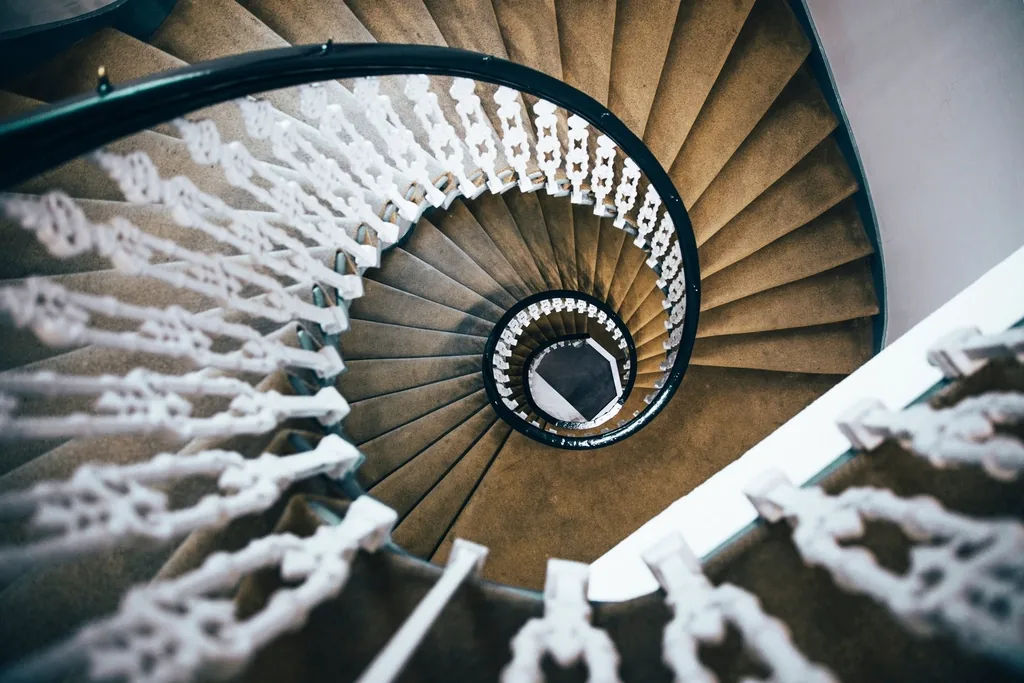 A spiral staircase viewed from above, evoking the spinning sensation of vertigo